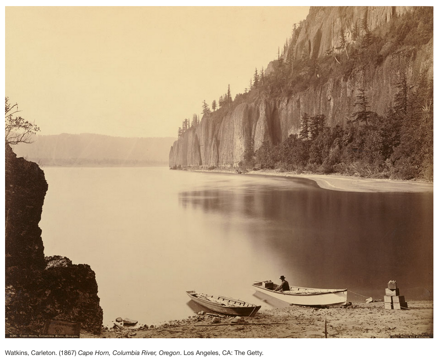 historic photo shows two rowboats ashore with Cape Horn in the background