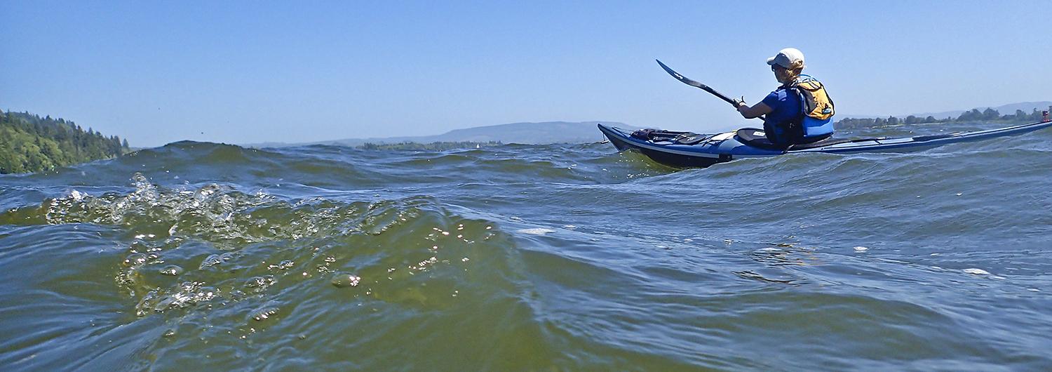 Woman rides the waves in a kayak