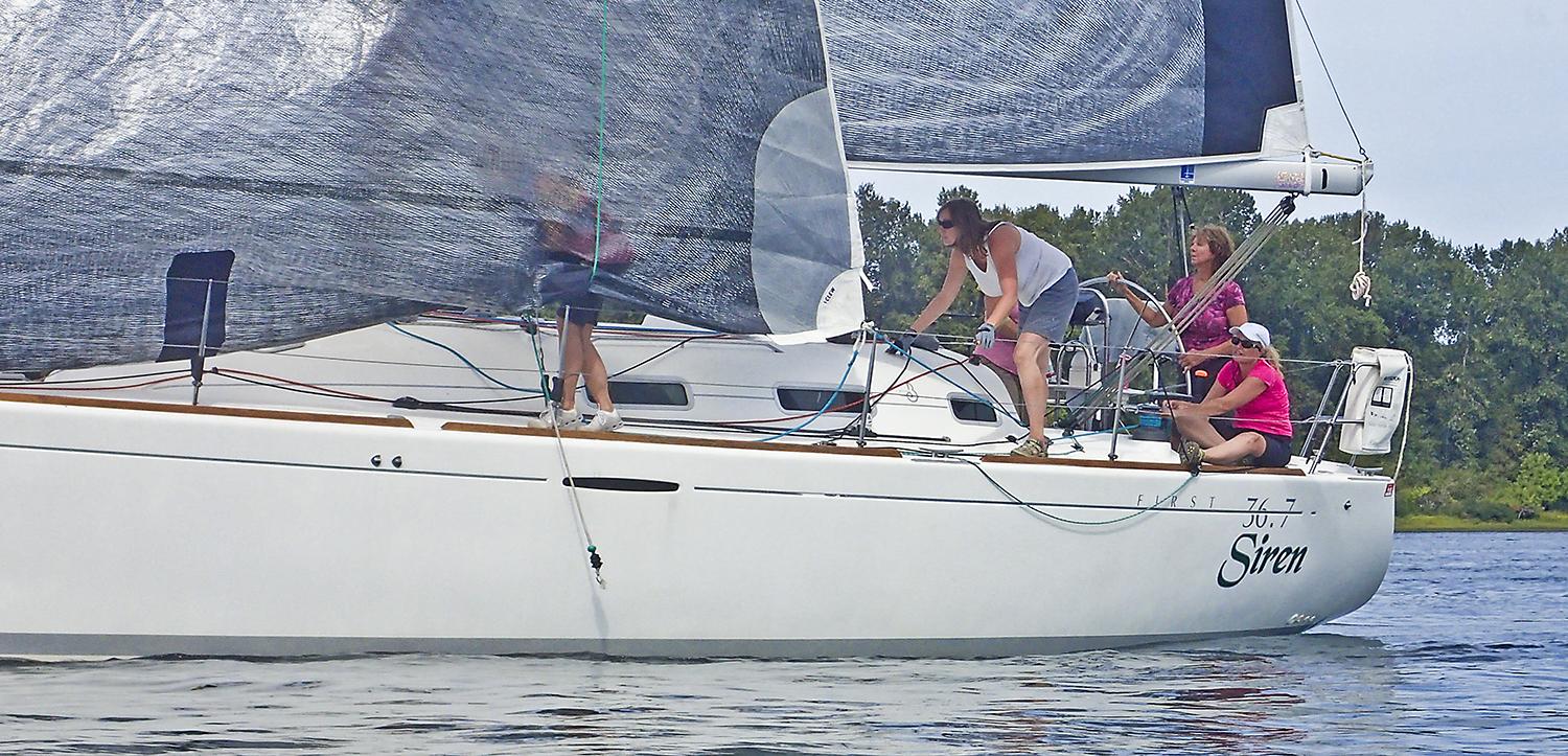 four women navigate on a sailboat