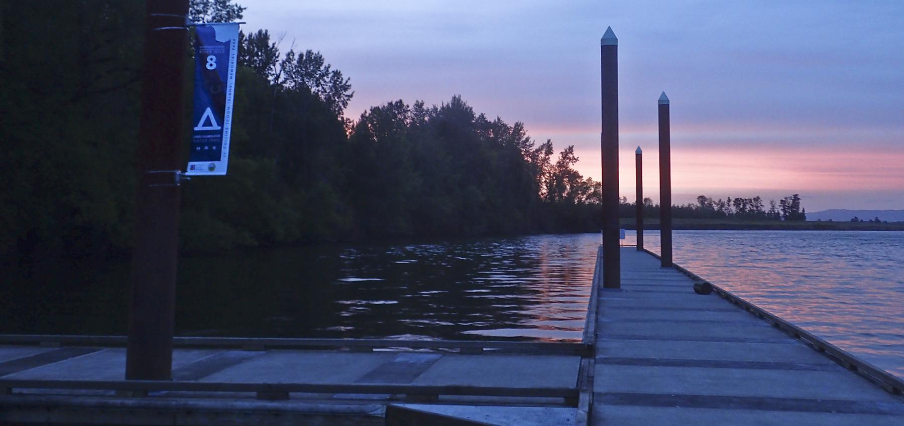 Lower Columbia River Water Trail river mile 8 sign posted on a dock during sunset